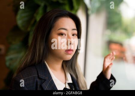 Jeune femme asiatique Office Worker / Data Scientist regardant la fenêtre Banque D'Images