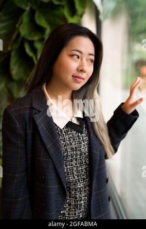 Jeune femme asiatique Office Worker / Data Scientist regardant la fenêtre Banque D'Images