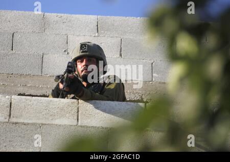 Naplouse, Palestine. 23 août 2021. Un soldat des forces d'occupation prend position lors d'une opération de recherche dans le village de Salem, à l'est de Naplouse, après que les Palestiniens ont lancé des pierres sur une voiture de colons sur la route de la colonie d'Elon Moreh. Crédit : SOPA Images Limited/Alamy Live News Banque D'Images