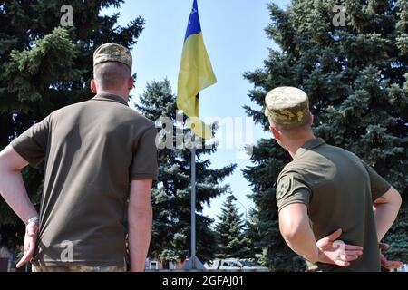 Marinka, Ukraine. 24 août 2021. Soldats de l'armée ukrainienne regardant le drapeau national sur le mât pendant le jour de l'indépendance.24 août, L'Ukraine célèbre le 30e anniversaire de son indépendance en l'honneur de l'adoption par la Verkhovna Rada de la RSS d'Ukraine en 1991 de l'Acte d'indépendance de l'Ukraine - un document politique et juridique qui a certifié le nouveau statut de l'Etat ukrainien. Crédit : SOPA Images Limited/Alamy Live News Banque D'Images