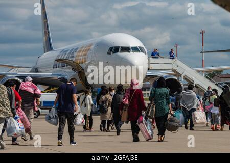 Ramstein Miesenbach, Allemagne. 24 août 2021. Les réfugiés afghans embarquaient à bord d'un avion commercial Atlas Air pour être transférés aux États-Unis après l'évacuation de Kaboul à la base aérienne de Ramstein le 24 août 2021 à Ramstein-Miesenbach, en Allemagne. Le Pentagone a appelé 18 avions civils de United Airlines, American Airlines, Delta Air, Atlas Air et Hawaiian Airlines en vertu de la loi sur la flotte aérienne de la Réserve civile pour aider à transférer les évacués dans le cadre de l'opération alliés refuge. Credit: Planetpix/Alamy Live News Banque D'Images