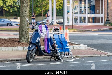 Scooter de moteur empilé avec des articles pour la plage garée à East Hampton, NY Banque D'Images
