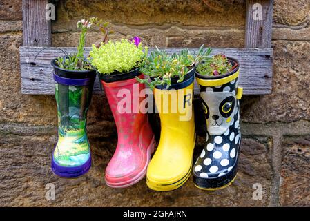 Pots de bottes de jardin rustique dans village rural - idées de jardin et de petit jardin design Banque D'Images