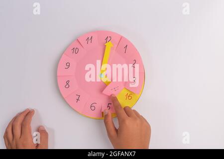 temps d'apprentissage des enfants avec horloge papier faite à la main, activité d'enseignement de l'heure préscolaire Banque D'Images