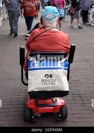 Une femme âgée conduisant un scooter motorisé avec un sac fourre-tout Princess Cruises visite un spectacle d'art en plein air à Santa Fe, Nouveau-Mexique. Banque D'Images