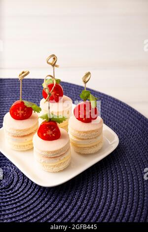 Délicieux en-cas de fête. Mini sandwiches ronds au jambon et au fromage décorés de tomates cerises sur un bâton de bambou Banque D'Images