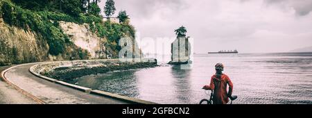 Femme de vélo de Vancouver sur une piste cyclable au parc Stanley célèbre siwash rock, activité touristique en Colombie-Britannique, Canada. Panorama de bannière. Cycliste sur route Banque D'Images