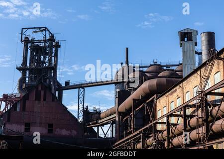 Usine d'acier abandonnée, ancien entrepôt en briques entouré d'énormes tubes et tuyaux, aspect horizontal Banque D'Images