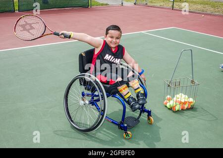 Miami Florida, Tropical Park paralympique expérience, handicapés tennis court fauteuil roulant hispanique homme garçon tenant raquette, Banque D'Images