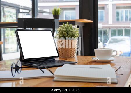 Prise de vue d'une tablette numérique avec écran blanc vierge, clavier, tasse de café sur le bureau Banque D'Images