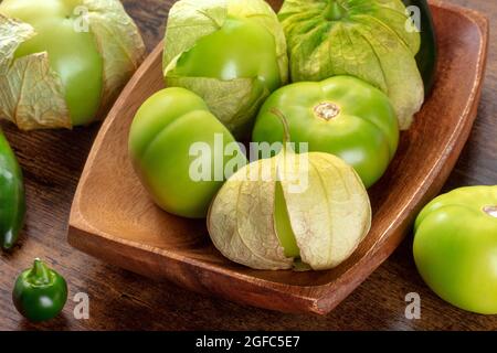 Tomatillos, tomates vertes, ingrédients de cuisine mexicaine sur fond de bois rustique foncé Banque D'Images