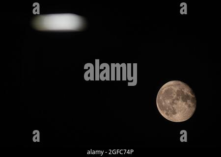 Londres, Royaume-Uni. 24 août 2021. Une pleine lune, également connue sous le nom de Sturgeon Moon d'août s'élève au-dessus de Twickenham à Londres. Crédit : SOPA Images Limited/Alamy Live News Banque D'Images