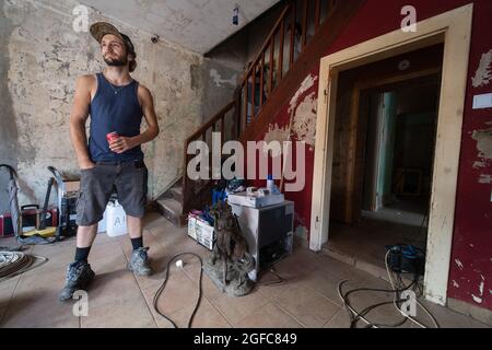 Schuld, Allemagne. 21 août 2021. Tim Himmes se tient dans le salon endommagé par les inondations de sa maison à Schuld. Le showman de 21 ans essaie depuis des semaines de nettoyer la maison familiale de boue et de saleté en grande partie par lui-même. S'éloigner n'est pas une option pour le jeune homme, sa famille a vécu dans le petit village sur la rivière Ahr pendant des décennies. (À dpa 'six semaines après l'inondation: 'La région a besoin d'une perspective' à partir de 25.08.2021) Credit: Boris Roessler/dpa/Alay Live News Banque D'Images