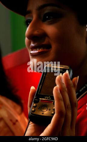 Ventes de téléphones mobiles filles à une arcade présentant de nouveaux modèles de téléphone. Bangladesh. Banque D'Images