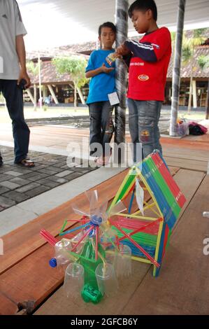 Un enfant faisant un modèle de maison à partir de plastique recyclé lors de la Journée des déchets plastiques, organisée par Walhi (Wahana Lingkungan Hidup), visait à sensibiliser à la nécessité de recycler les plastiques. Bantul, Yoyakarta, Indonésie. 13 avril 2008. Banque D'Images