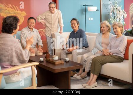 Des amis heureux parlant dans le salon Banque D'Images