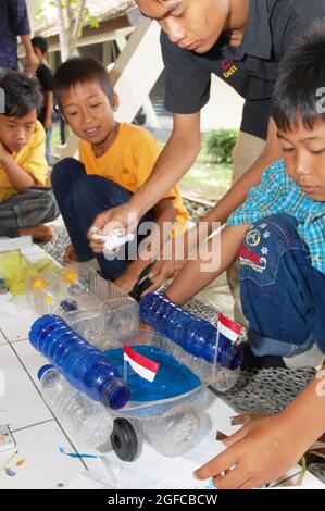 Les jeunes qui font des jouets à partir de plastique recyclé lors de la Journée des déchets plastiques, organisée par Walhi (Wahana Lingkungan Hidup), ont pour but de sensibiliser les gens à la nécessité de recycler les plastiques. Bantul, Yoyakarta, Indonésie. 13 avril 2008. Banque D'Images