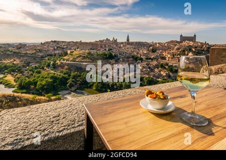 Verre de vin blanc avec tapas servi sur une table avec vue sur Tolède, Castille-la Manche, Espagne Banque D'Images