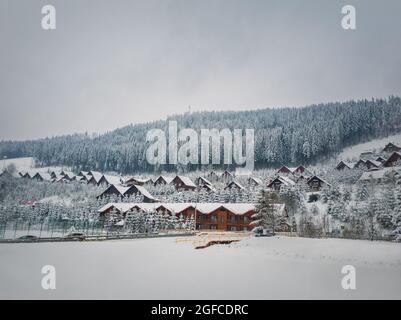 Station de ski de Bukovel, hôtels de cabine de ville couverts de neige par une froide journée d'hiver. Vacances et destination de vacances dans les montagnes carpathes ukrainiennes. Banque D'Images