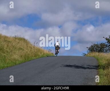 Cycliste mature, homme, qui se déchire sur une colline, au creux de Bowland, Lancashire, Royaume-Uni. Banque D'Images