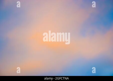 Des nuages orange pinky moelleux contre un ciel bleu au coucher du soleil Banque D'Images