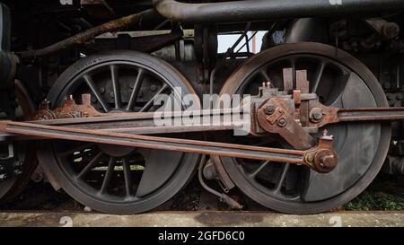 Gros plan des roues motrices et bielles de locomotive à vapeur, montrant l'ingénierie ferroviaire d'époque et les détails mécaniques. Banque D'Images