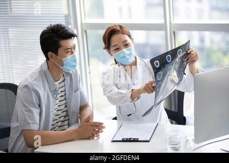 Médecin discutant de l'image radiologique avec le patient Banque D'Images