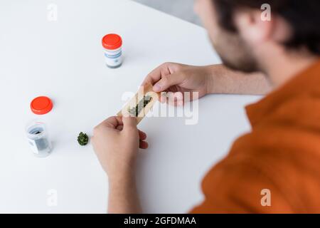 vue partielle de l'homme malade faisant l'articulation avec le cannabis médical à la maison Banque D'Images