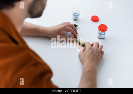 vue rognée de l'homme malade faisant joint avec le chanvre médical à la maison Banque D'Images