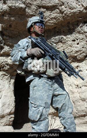 SPC. Ham de Charlie Company, 2/87 Infantry, garde à l'extérieur d'une grotte que d'autres soldats de Charlie Company recherchent et défrient. Les soldats ont participé à l'opération Catamount Fury, une mission de la taille d'un bataillon qui s'est déroulée dans la province de Paktika en Afghanistan, en mars 29, et qui visait à limiter le mouvement des Taliban à l'intérieur de Paktika. Banque D'Images