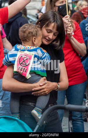 Londres, Royaume-Uni - 25 août 2021, UNE femme tient un enfant avec un signe de rébellion d'extinction sur le dos lors d'une manifestation devant l'ambassade du Brésil à Londres.des manifestants se sont rassemblés devant l'ambassade du Brésil à Londres pour appeler à la fin des attaques génocidaires menées contre les peuples autochtones du Brésil. Les partisans de la rébellion amazonienne, Brazil Matters, CAFOD, Greenpeace, parents pour l'avenir et Survival International protesteront pour mettre fin au génocide brésilien dans le cadre de la lutte mondiale pour la vie (« Luta pela Vida ») menée par l'Association des peuples autochtones du Brésil (APIB). Banque D'Images