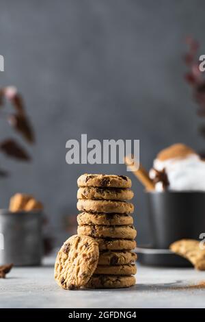 Une pile de délicieux biscuits avec des chips de chocolat et une tasse de café avec de la crème fouettée. Banque D'Images