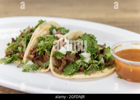 Copieuse commande de carne asada steak rue tacos rempli de viande, coriandre, et oignons. Banque D'Images