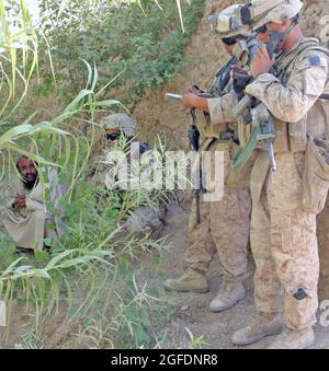 Marines avec Golf Company, 2e Bataillon, 9e Régiment de Marine, recueille des renseignements auprès d'un afghan local lors d'une opération de recensement à Marjah, Afghanistan, août 16. L'équipe a été attaquée à mi-chemin par la patrouille et a engagé les talibans ennemis dans le processus. Banque D'Images