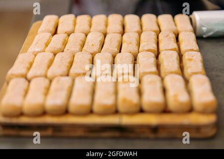 Biscuits à biscuits pour la fabrication de tiramisu. Les Savoyards sont disposés sur une planche à découper. Gros plan. Banque D'Images