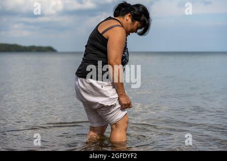 Une femme asiatique d'âge moyen au bord d'un lac Banque D'Images