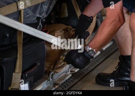 Les employés du terminal de passagers de Royal Air Force Mildenhall sécurisent une palette de bagages avant de la transporter à un avion de la RAF Mildenhall, en Angleterre, pour que le 48e avion du Groupe médical se déploie à la base aérienne de Ramstein, en Allemagne, afin d'aider à la refuge de l'opération alliés le 23 août 2021. Lorsqu'ils seront déployés à Ramstein, les militaires du 48e OMD vont accroître les efforts du 86e personnel du Groupe médical pour assurer la santé et la sécurité des Afghans hébergés sur l'installation. (É.-U. Photo de la Force aérienne par Airman 1ère classe Cedrique Oldaker) Banque D'Images