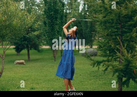 Jeune femme adulte jouant au badminton dans le parc. Banque D'Images