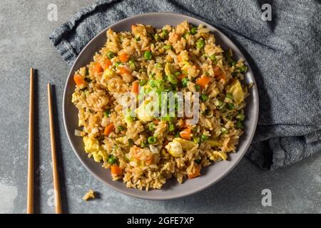 Riz frit chinois maison avec œufs, carottes et petits pois Banque D'Images