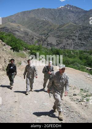 Scott Davis (avant), représentant de la construction du corps d'ingénieurs de l'Armée attaché à l'équipe provinciale de reconstruction Panjshir et un Omaha, Nb., natif, et 2e lieutenant Jason Adams (arrière, à droite), PRT Panjshir génie civil et Glendale, Ariz., natif, marchez avec un interprète et une garde locale des moudjahidines. L'EPR a plus de 30 projets de reconstruction en cours dans la vallée, et les ingénieurs en inspectent plusieurs chaque semaine. Banque D'Images