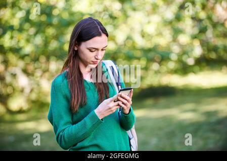 Young woman text messaging on smart phone Banque D'Images