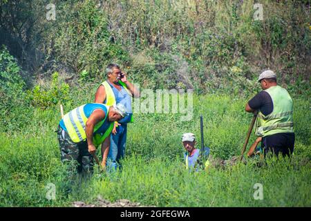 Anapa, Russie - 08.21.2019: Équipe de travail creusant une tranchée lors d'une journée d'été Banque D'Images