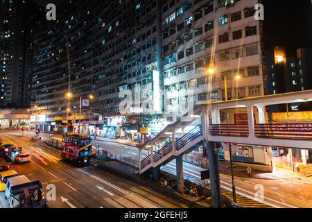 Vue sur le bâtiment et les boutiques avec véhicule en mouvement dans la rue, Hong Kong Banque D'Images