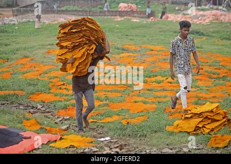 Dhaka, Bangladesh. 25 août 2021. DHAKA CITY, BANGLADESH - AOÛT 25: Un travailleur de Hazaribagh met des morceaux de cuir à sécher dans le cadre du processus de tannage du cuir dans une petite usine pour le vendre à la fabrication de chaussures. Le bronzage consiste à tremper les peaux, puis afin d'éliminer le sel dans une solution de chaux et d'eau pour ramollir les cheveux et les éliminer à l'aide d'une machine, puis les résidus sont enlevés à la main avec un couteau émoussé. Le 25 août 2021 à Dhaka, au Bangladesh. (Photo d'Eyepix/Sipa USA) crédit: SIPA USA/Alay Live News Banque D'Images