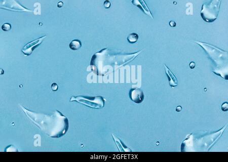 Texture cosmétique de gel d'aloès ou de frottis de masque hyaluronique. Effacer les breloques de soin de la peau sur fond bleu, concept de produit nettoyant pour le visage Banque D'Images
