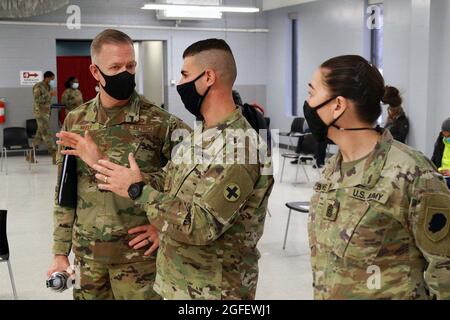 2e Lt. Fahim Masoud, centre, briefings Major général Rich Neely, à gauche, l'Adjutant général de l'Illinois et commandant de la Garde nationale de l'Illinois et le Sgt de commandement. Le Maj. Dena Gallowe, chef principal de la Garde nationale de l'Illinois, lors d'une visite au site de vaccination de masse COVID-19 dans le comté de Cook, à Chicago, en Illinois. Banque D'Images