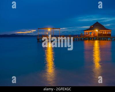 Ora Beach, Indonésie - 14 février 2018 : maisons sur l'eau dans le complexe Ora Beach, nuit. SERAM Island, Centre de Maluku, Indonésie Banque D'Images