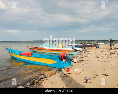 Kaimana, Arguni Bay, Indonésie - février 2018 : problème de pollution. Bateaux en bois et plein de déchets sur la plage à marée basse au port d'un petit Banque D'Images