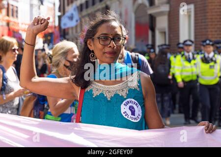 Extinction rébellion protestataires à Oxford Circus protestant contre le changement climatique. Dame en robe bleue tenant son poing dans l'air. Banque D'Images