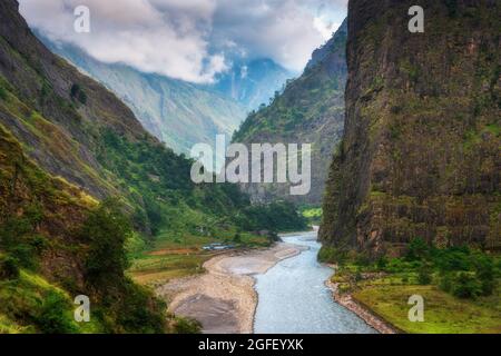 Petit village sur la côte de la rivière dans les montagnes de l'Himalaya Banque D'Images
